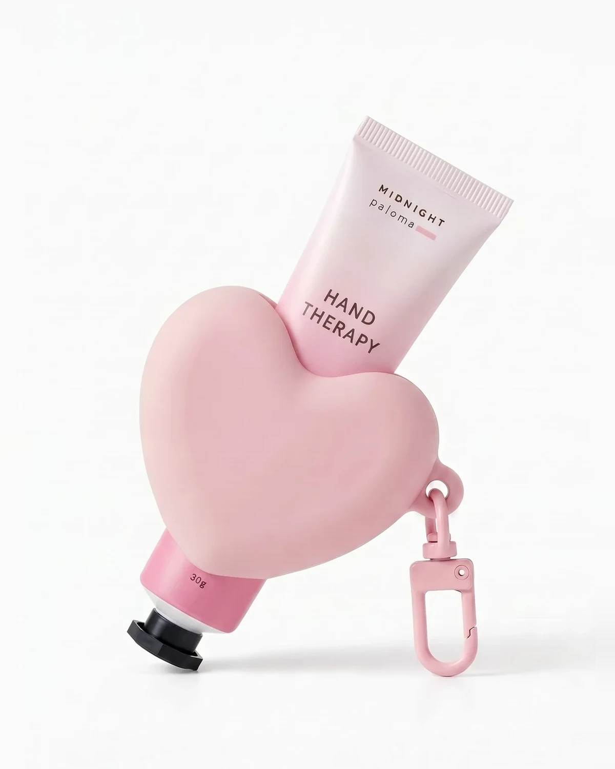 Midnight Paloma pink heart-shaped On The Go Keychain holding a 30 g Hand Therapy mini (hand cream sold separately)