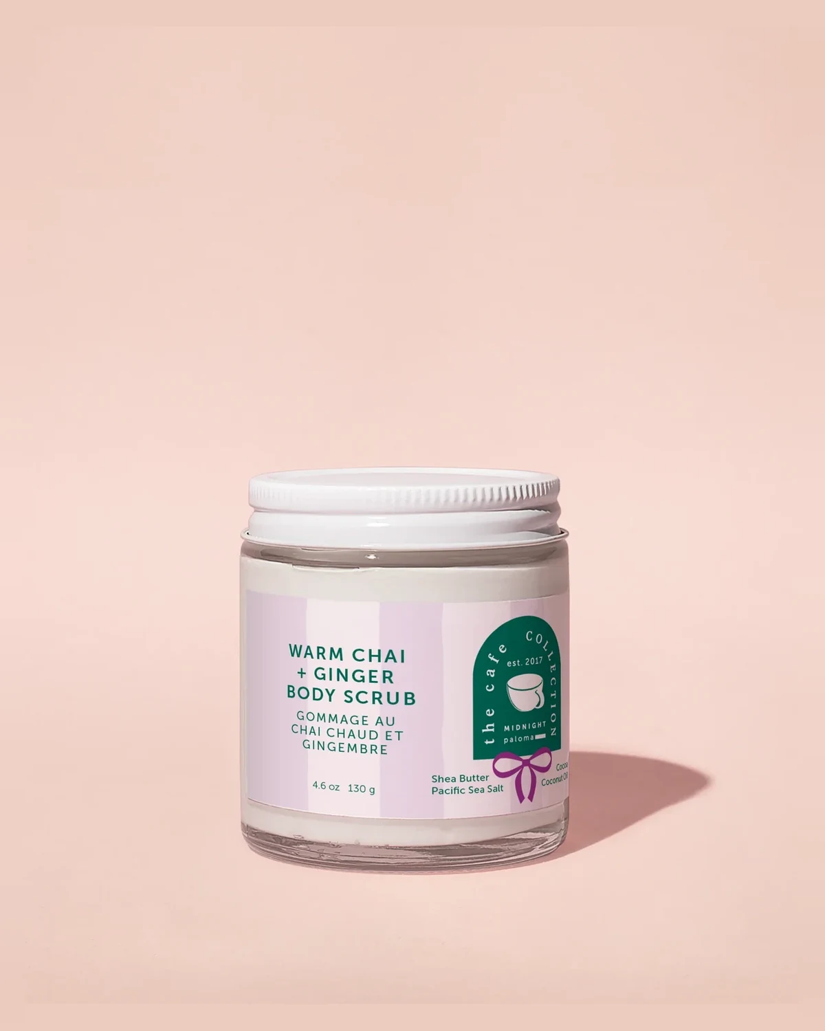 Midnight Paloma Warm Chai + Ginger Body Scrub, 4.6 oz (130 g) glass jar from The Cafe Collection, on a peach background