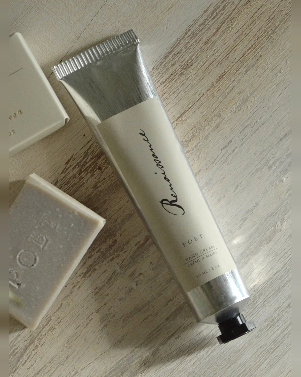 Poet Farm Renaissance hand cream in its 60 mL aluminum tube on a wooden surface